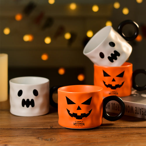 Pumpkin and ghost mugs side by side on a wooden table