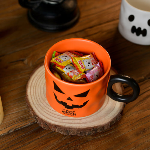 Pumpkin mug filled with wrapped Halloween candy