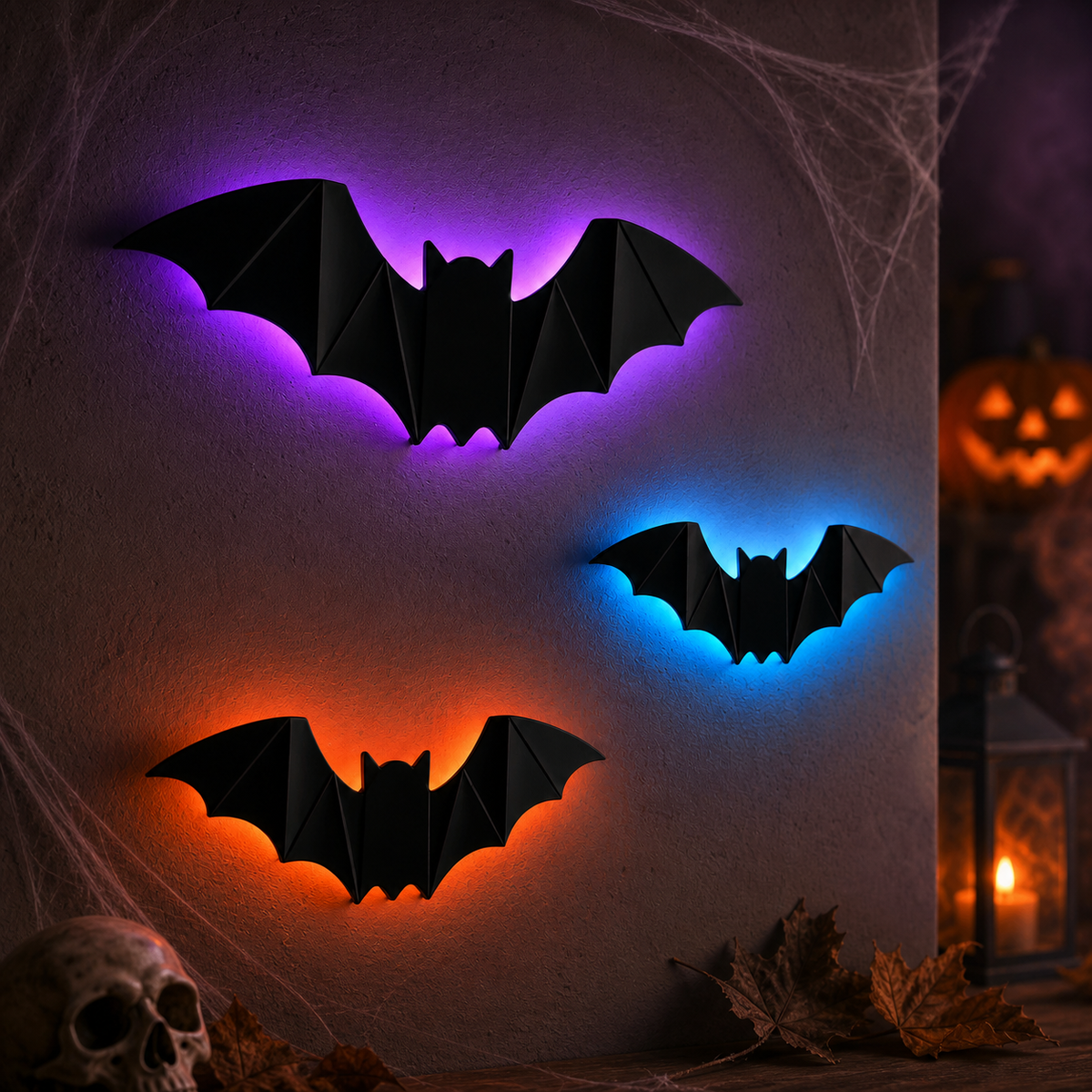 BatGlow bats glowing purple, blue and orange beside a lit jack-o'-lantern and cobwebs