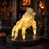 Skeleton hand on a dark bar top beside apothecary bottles