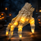 Skeleton hand crawling on rustic wood boards beside jack-o'-lanterns